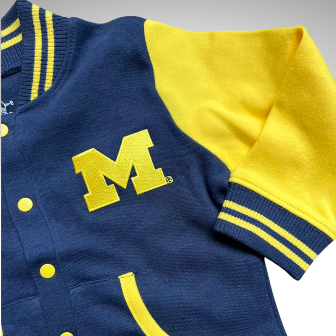 Blue and yellow varsity jacket with a large 'M' logo on a gray background