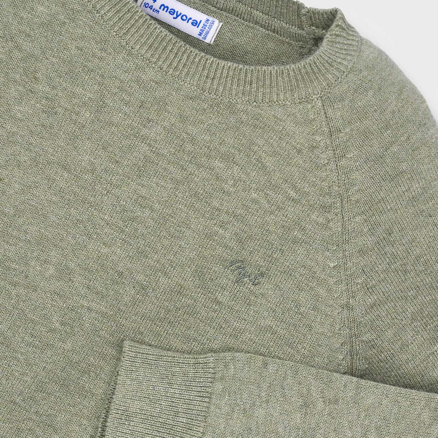 Green sweater with a pocket and visible brand label on a light gray background