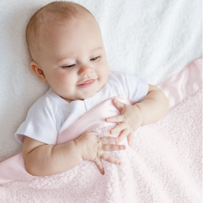 baby under pink blanket