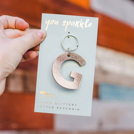 Keychain with letter 'G' held on a card with 'you sparkle' text.