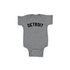 Gray baby onesie with 'DETROIT' printed on it against a white background