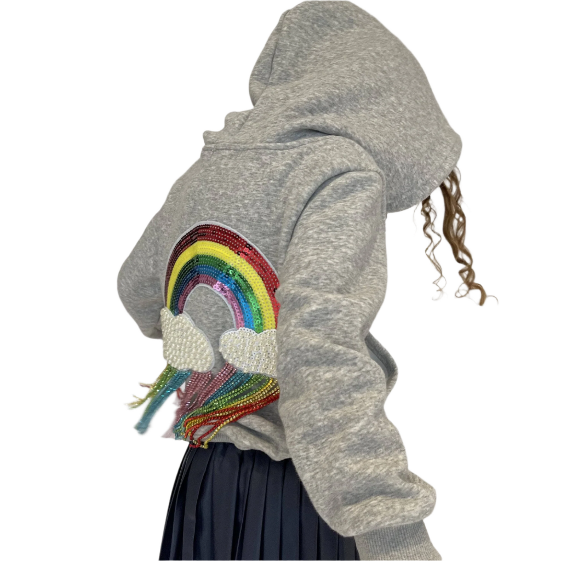 Person wearing a gray hoodie with a rainbow design on a plain background