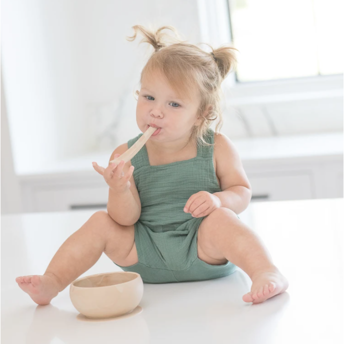 baby using wood spoon